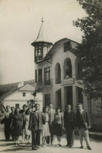 Group of people posing on a street in front of a building.