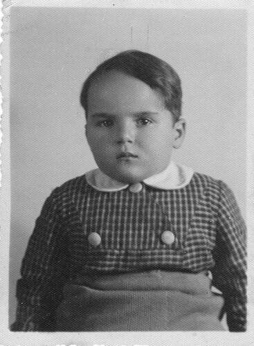 A young child gazing at the camera with a serious expression.