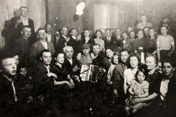 The first and possibly only postwar Jewish wedding to take place in Sochaczew. Andrew is in front, sixth from the right, and his father, Henryk, is in the centre seated next to the soldier in uniform. 1945. Courtesy of Crestwood Oral History Project.