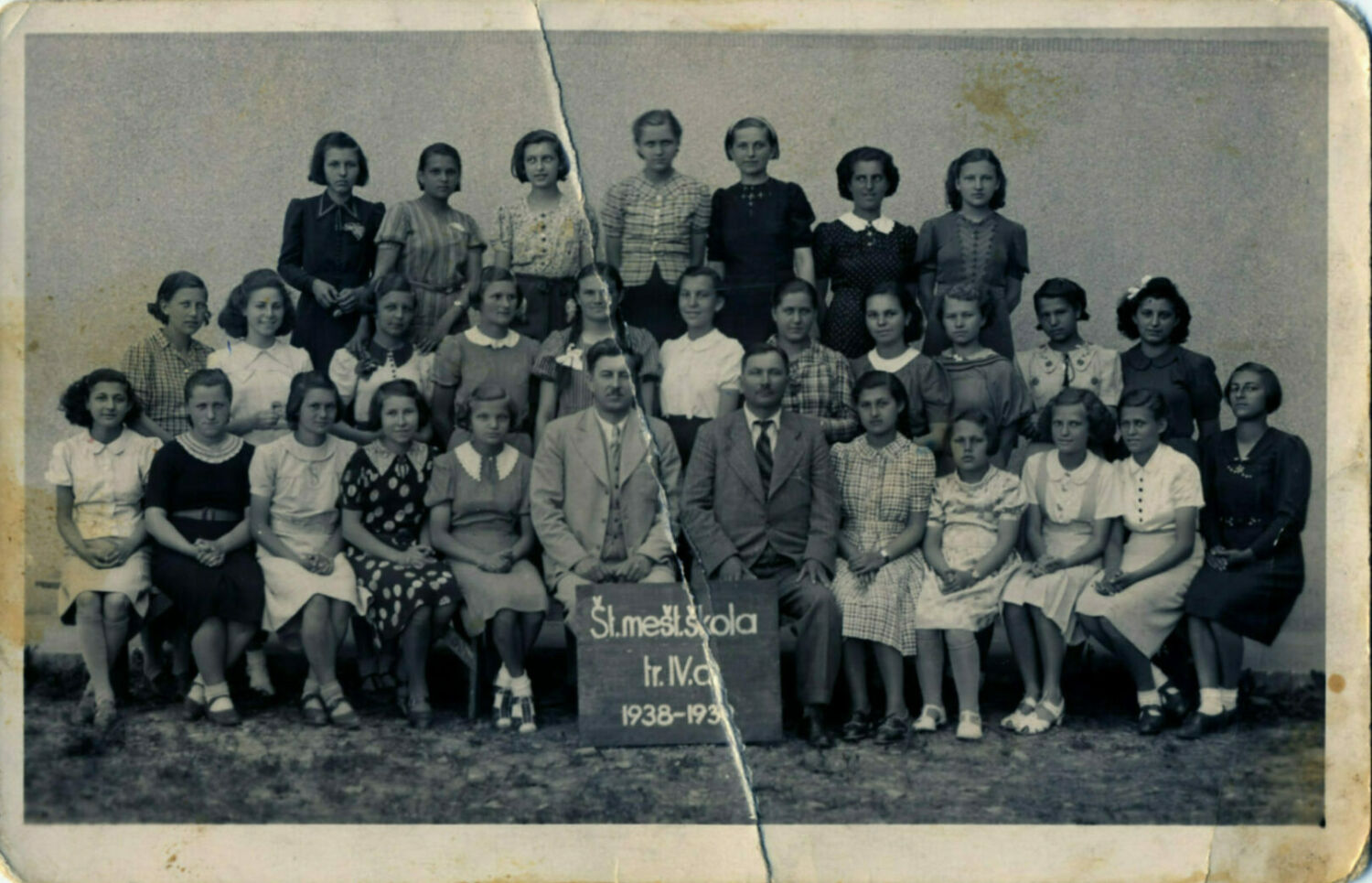 Class photo of girls with two teachers sitting in the front and center.
