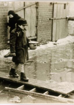 Un enfant tenant un bol de soupe traverse une rue inondée sur une planche de bois dans le ghetto de Łódź (Pologne), vers 1940-1944.
United States Holocaust Memorial Museum, avec l’aimable autorisation d’Arie Ben Menachem.