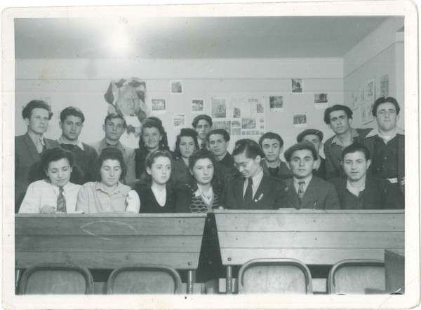 Un groupe d’adolescents plutôt sérieux s’est rassemblé derrière deux pupitres pour la photo de classe.